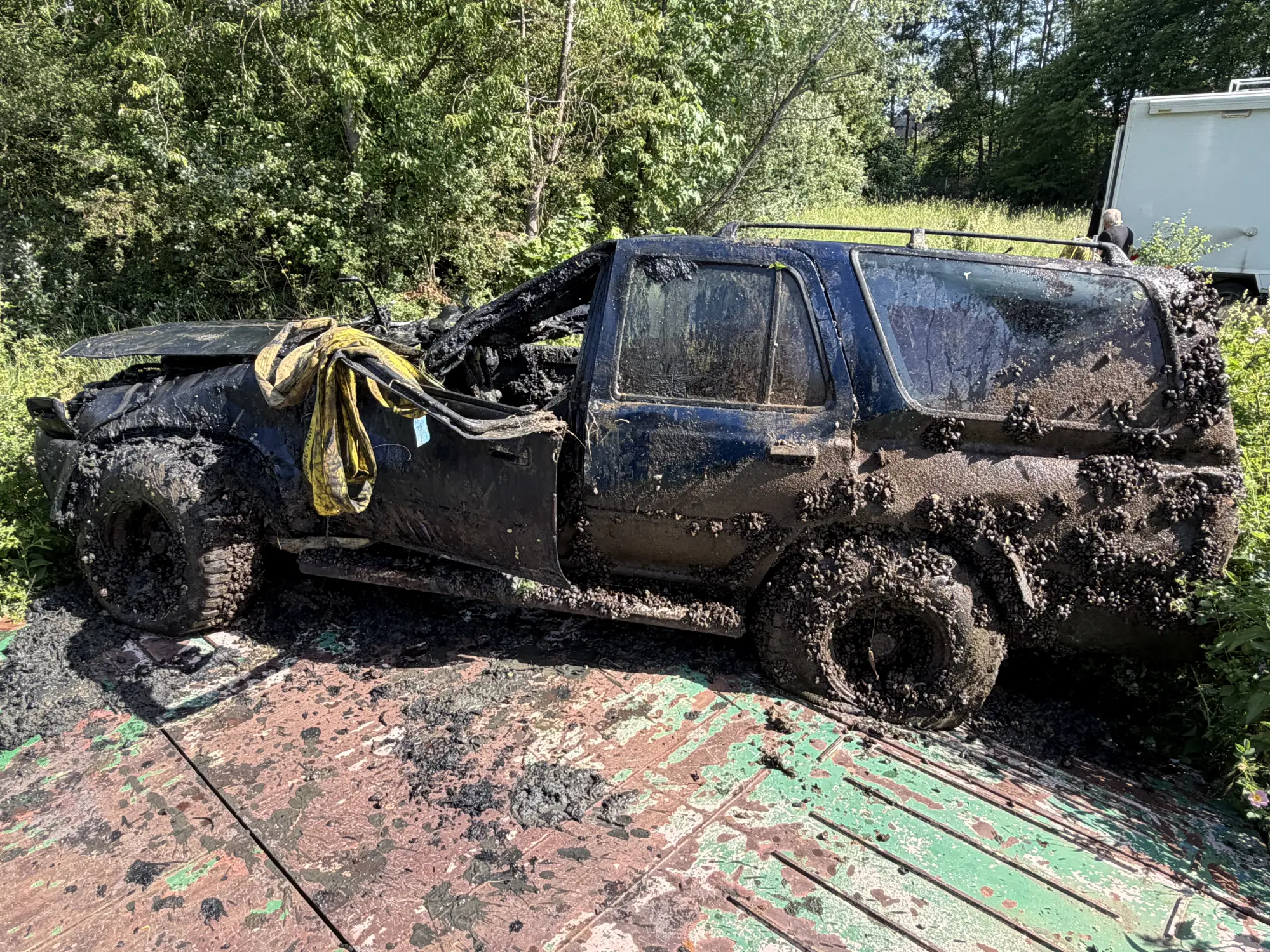 Komplett zerstörtes Auto, voller Dreck steht am Ufer am Main-Donau-Kanal