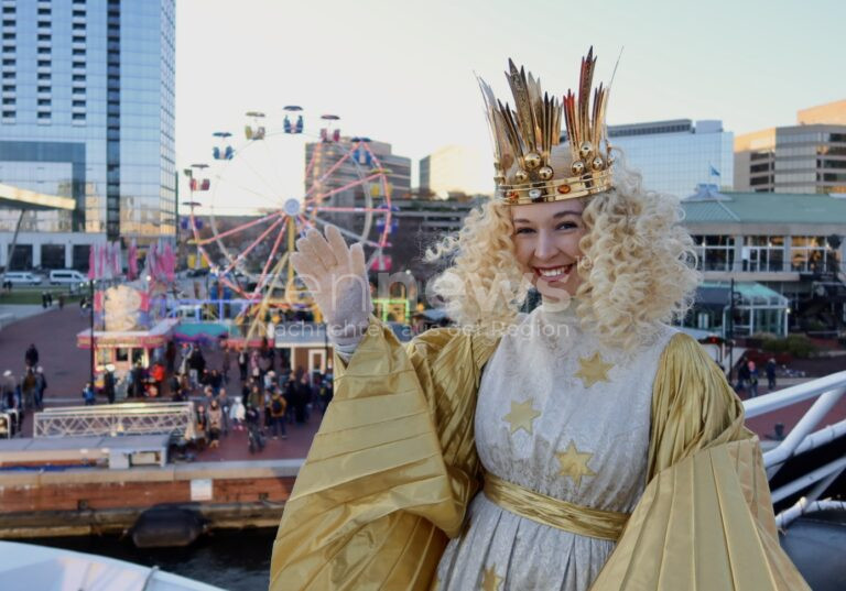 Nürnberger Christkind in den USA! Teresa Windschall eröffnet Weihnachtsmärkte in Baltimore & Philadelphia. Deutsche Tradition trifft internationale Freude - Christkind Teresa Windschall vor dem Riesenrad des Christmas Village in der US-Stadt Baltimore.